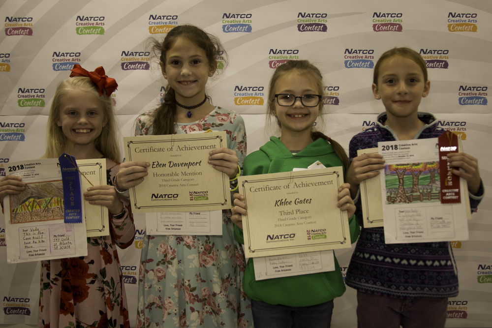 4 children holding award certificates