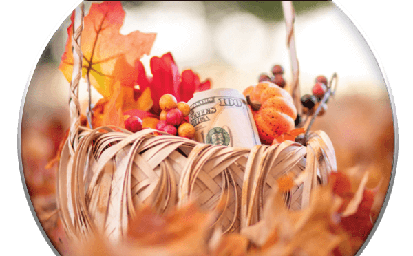 Fall leaves and berries in a basket with a hundred dollar bill